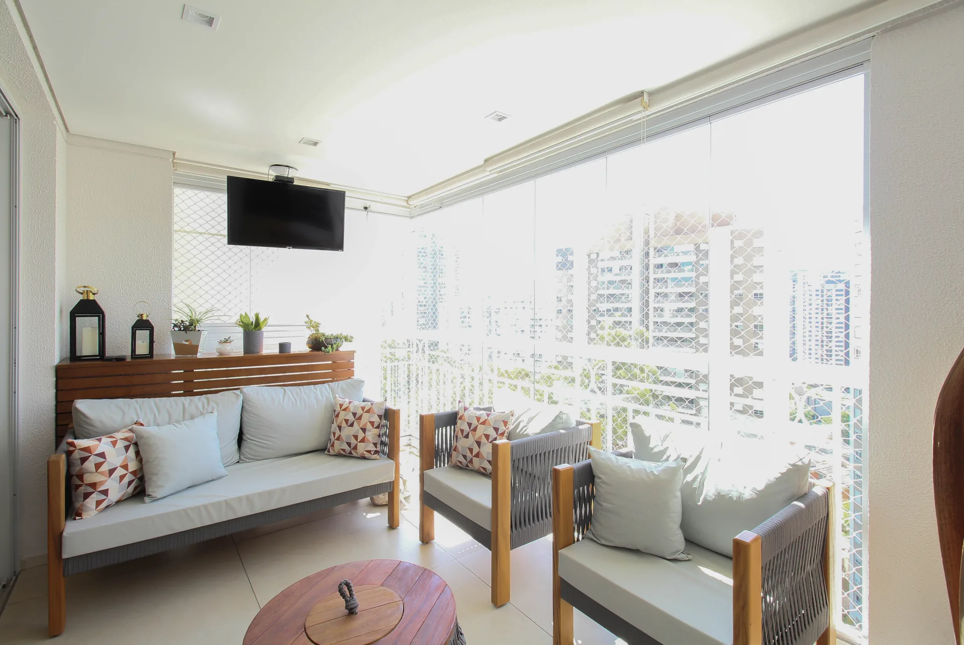 Varanda envidraçada com área de estar e vista urbana no Condomínio Taman Vila Andrade